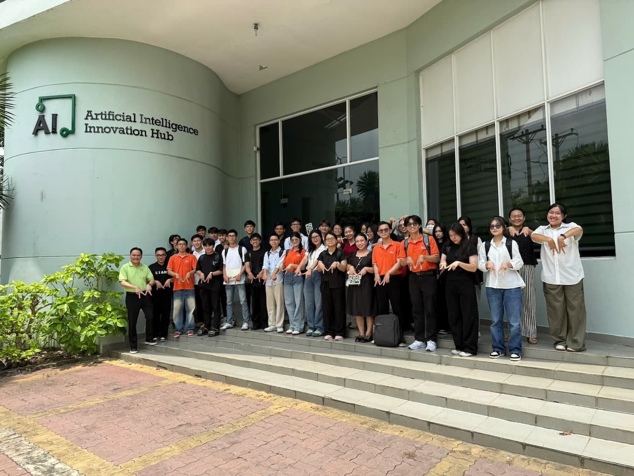 Staff and students posing on steps with orange and teal electric bikes